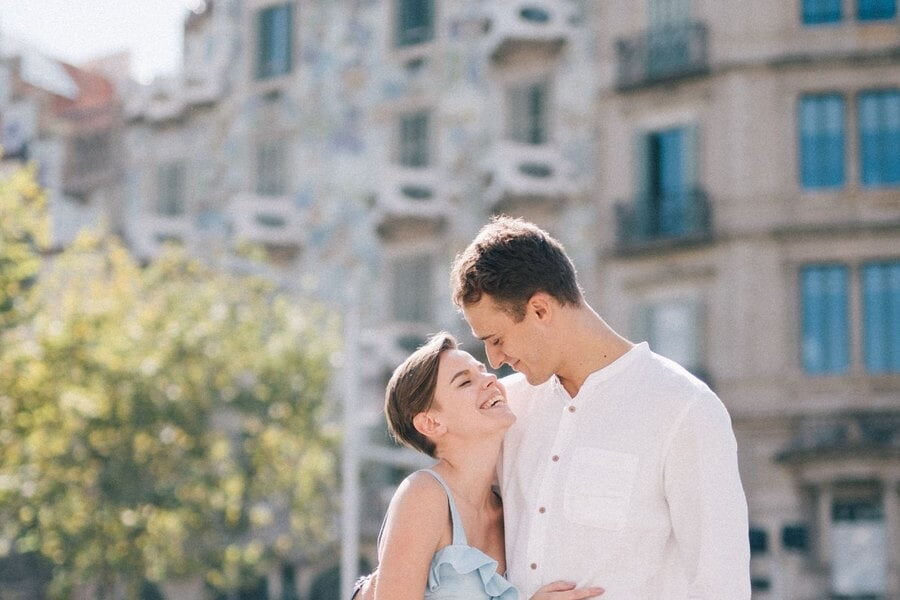 Una pareja sonriente se abraza frente a la Casa Batlló, en Barcelona