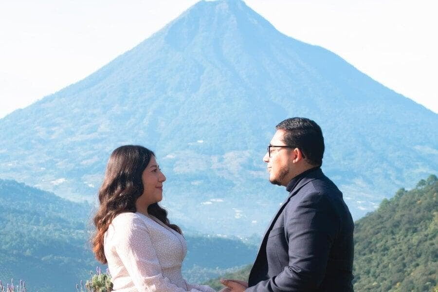 Una pareja se toma de las manos con un volcán de fondo en Guatemala