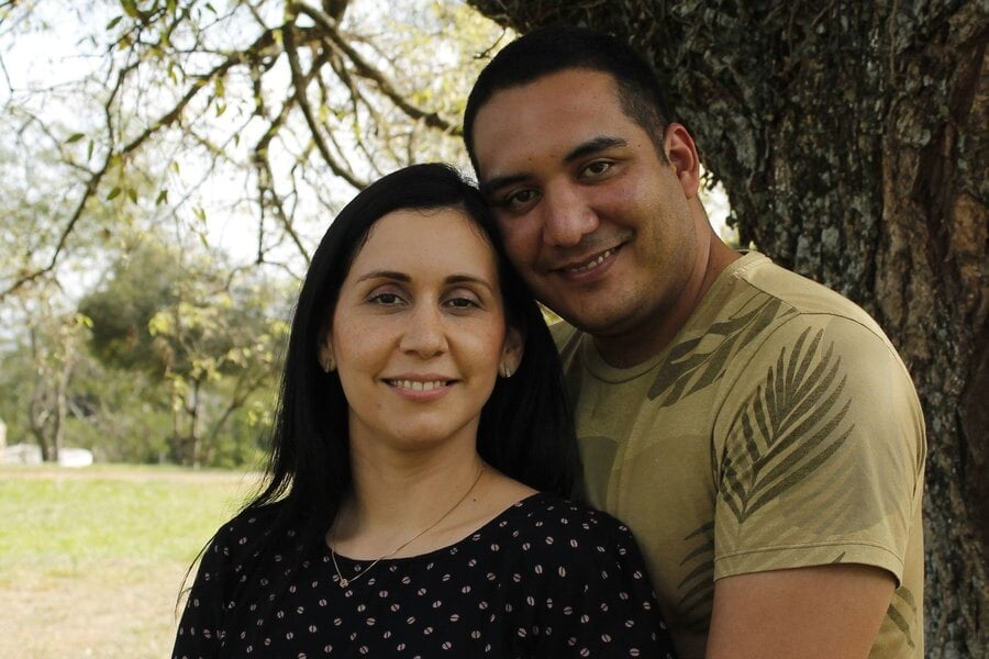 Una pareja sonriente se abraza bajo un árbol en Caacupé, Paraguay